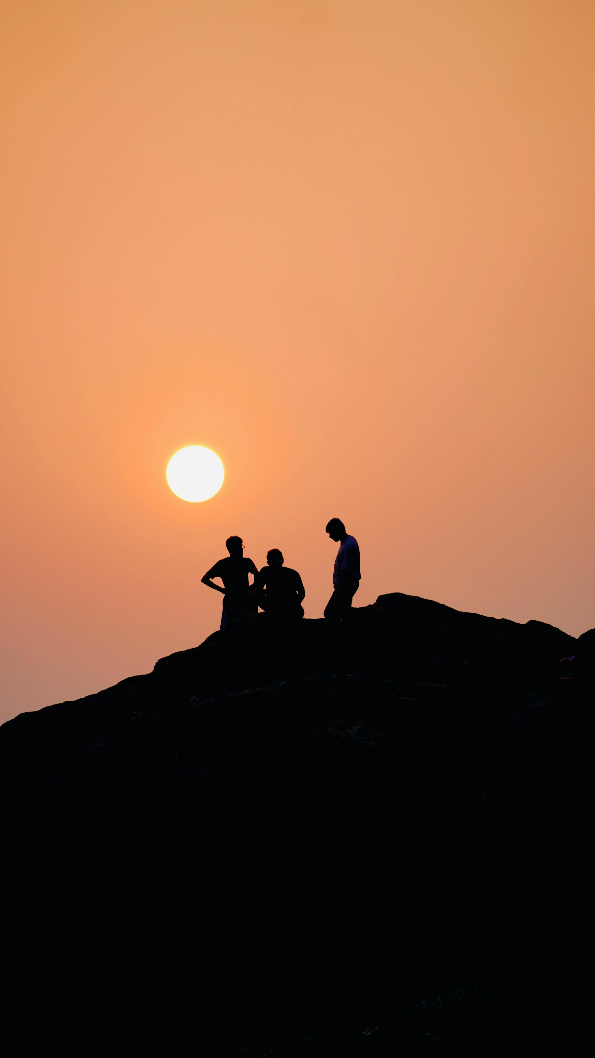 a group of people sitting on top of a hill